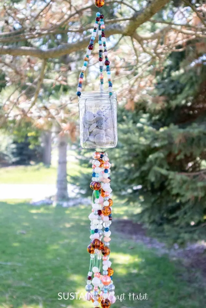 Hanging mason jar wind chime made with beads and wire.