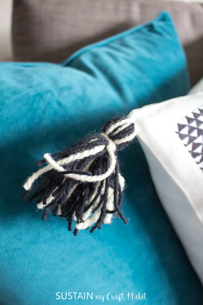 Attaching the tassel to a throw pillow.