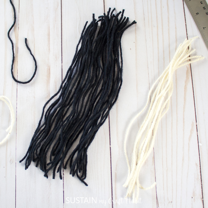 Cut strands of white and black yarn.