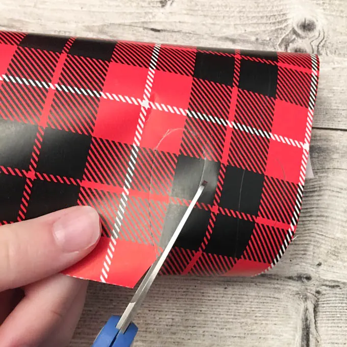 Cutting out the traced shapes on the plaid gift wrap.