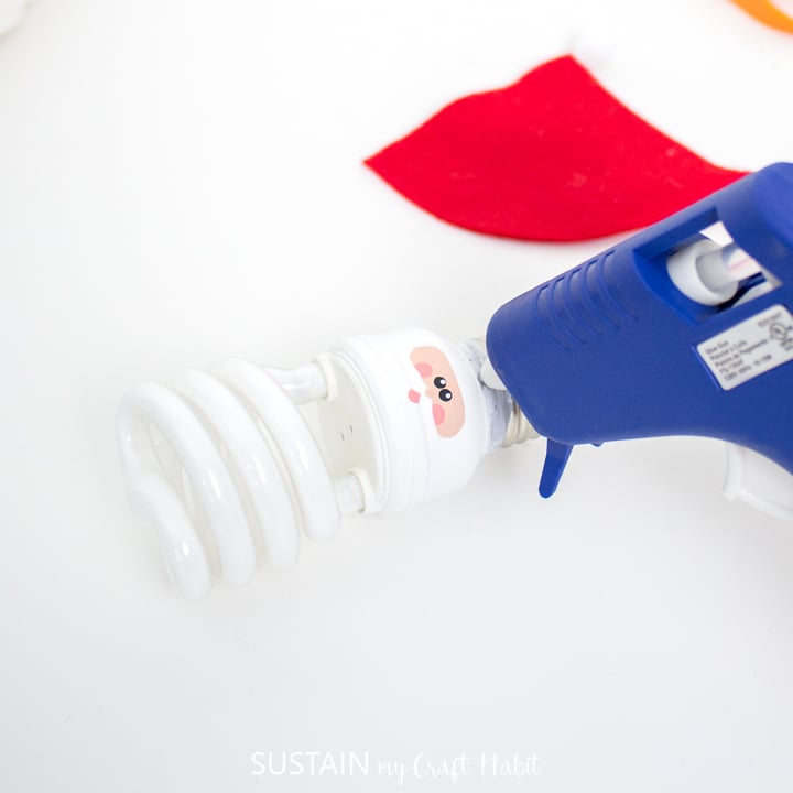 Adding hot glue to the top of the light bulb.