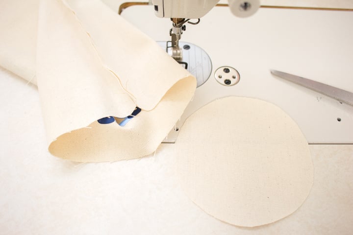 Sewing the circle canvas fabric to the sewn tube shape.