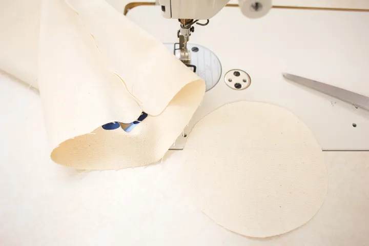 Sewing the circle canvas fabric to the sewn tube shape.