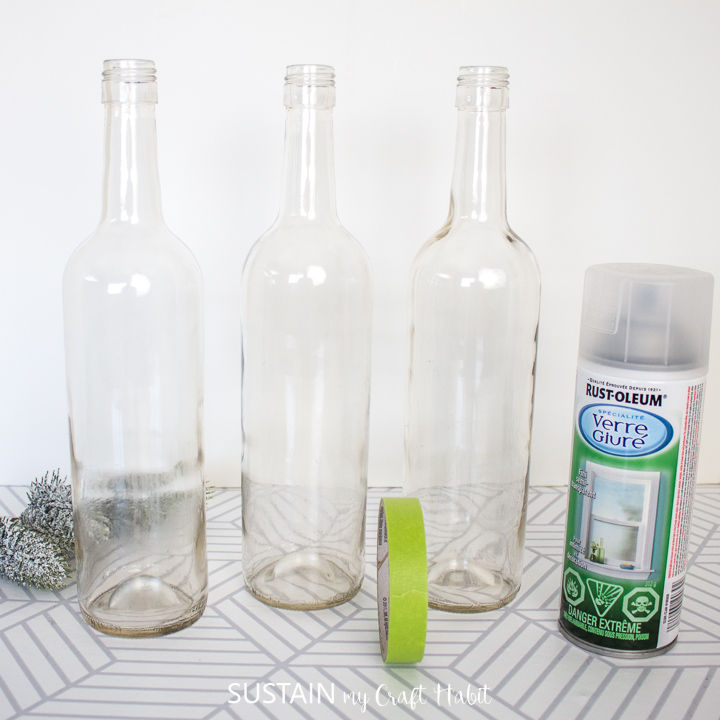 Materials needed to make Frosted wine bottle centerpieces including wine bottles, spray paint and painters tape.