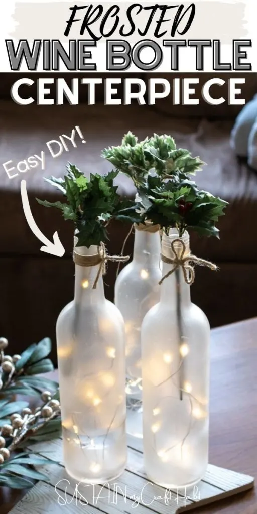 Frosted wine bottle centerpieces arranged with twinkle lights and fresh greenery including text overlay.