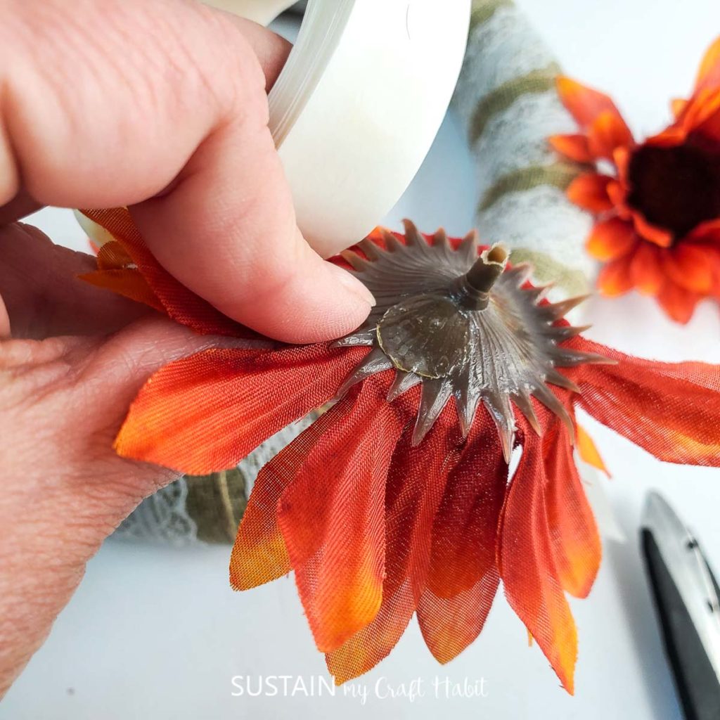 Adding a glue dot on the back of the plastic sunflower.