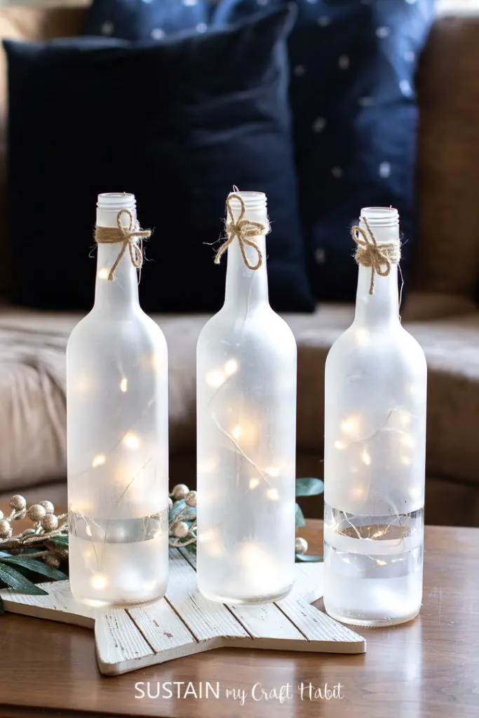 Frosted wine bottle centerpieces with twinkle lights.
