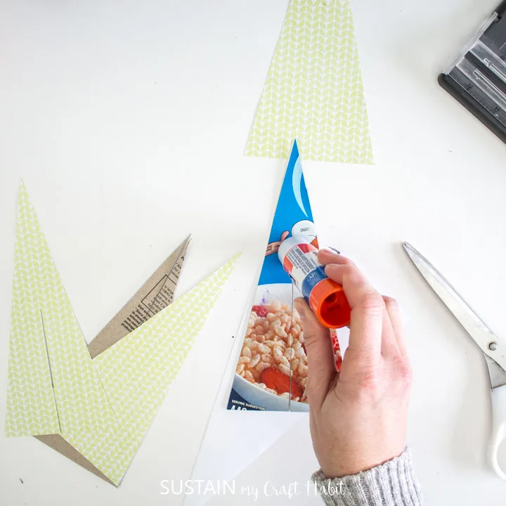 Adding glue to the cut out cardboard trees.