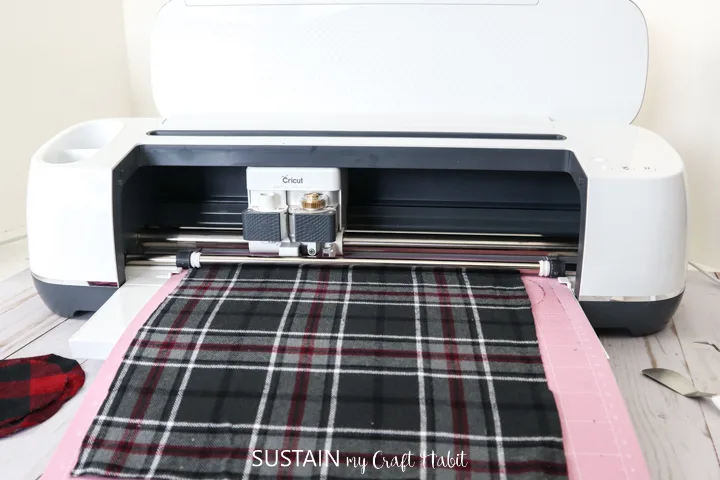 Inserting the flannel fabric into the Cricut machine.