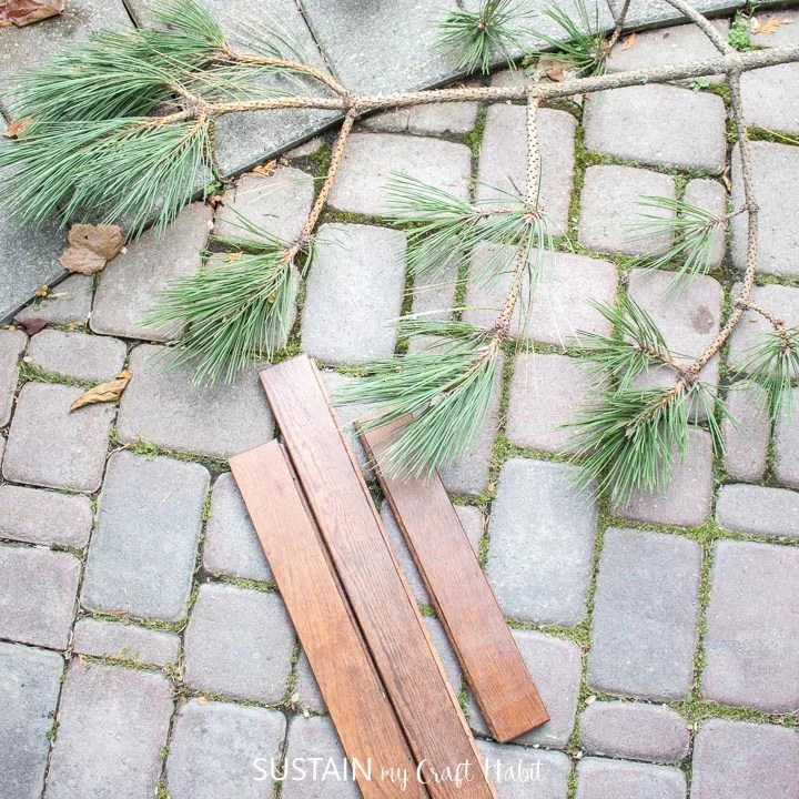 A piece of pine tree and wood planks on a stone path.