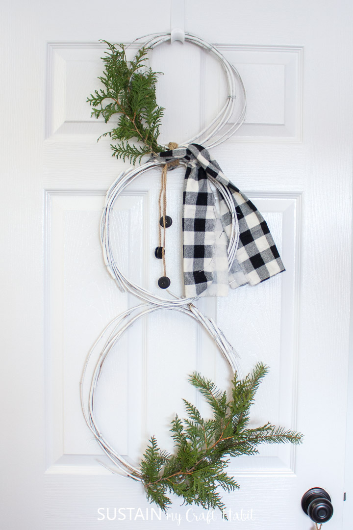 Snowman wreath made from mulberry vines hanging from a door.
