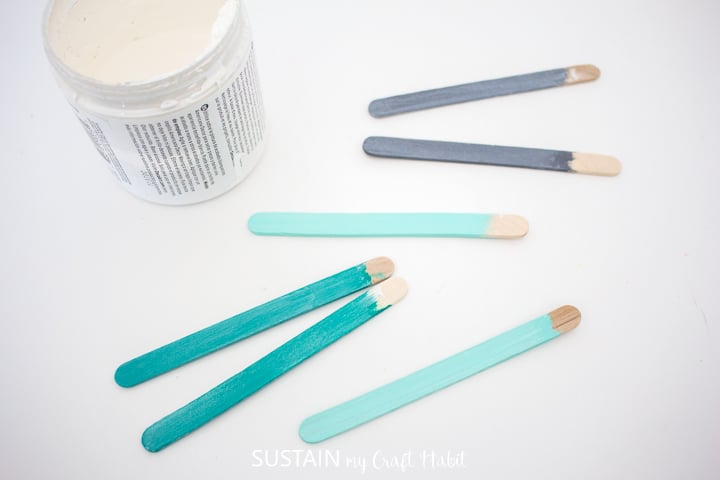 Rubbing creme wax onto the painted popsicle sticks.