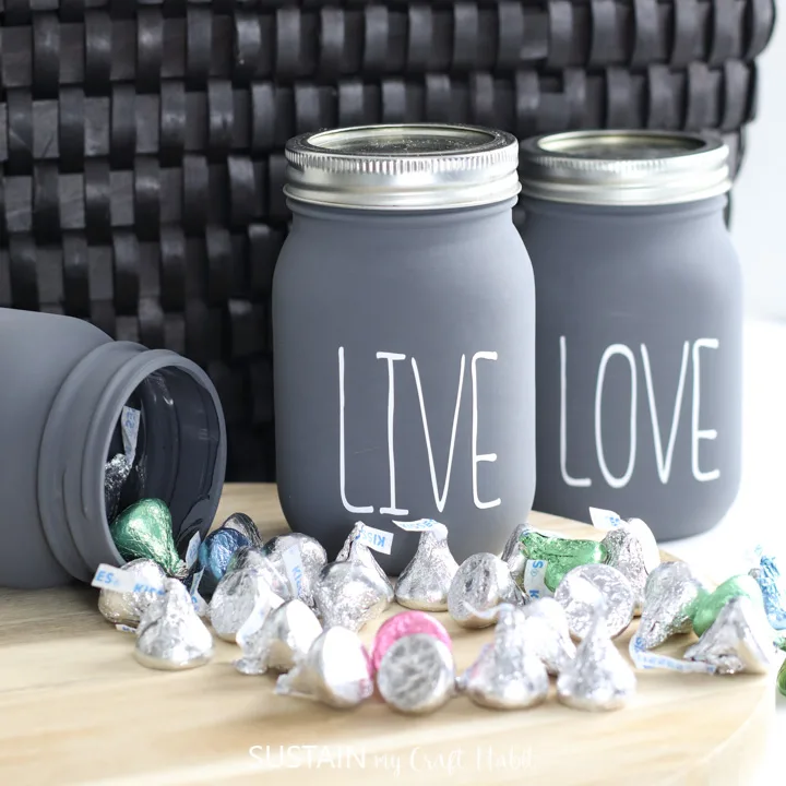 chalky painted jars on a table with hershey kisses spilling out
