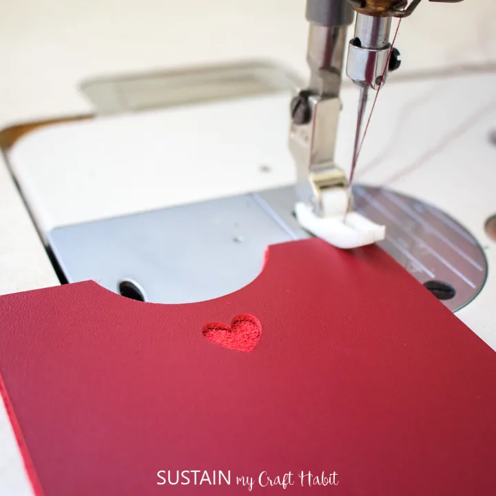 Sewing the red leather phone sleeves together.