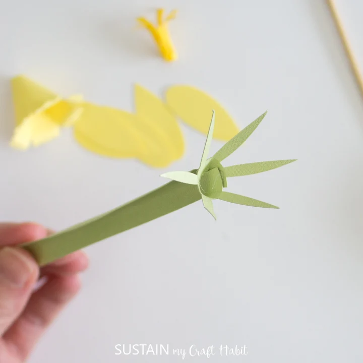 Gluing the paper petals onto the paper stem.