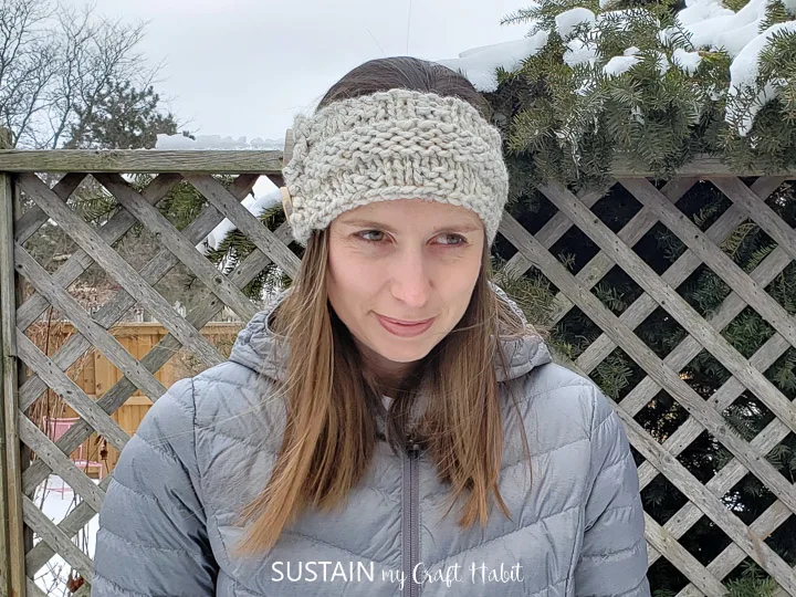 Woman wearing head band knitted from the free pattern.