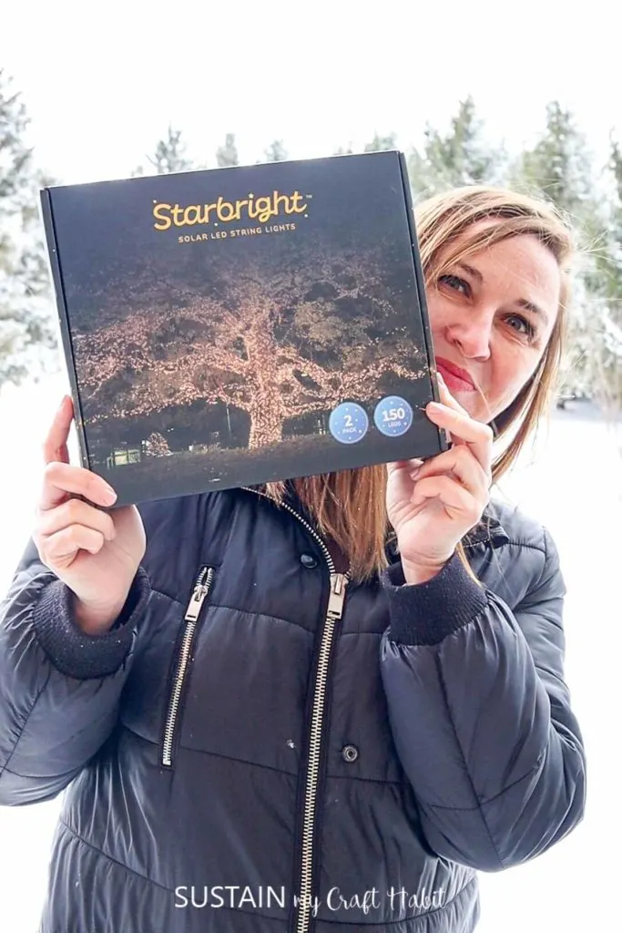 woman holding box of Starbright Solar LED String Lights by Brightology