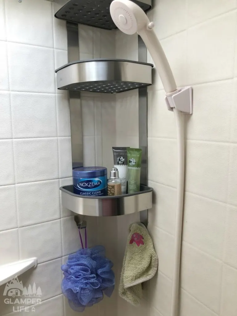 Silver shower caddy with toiletries.