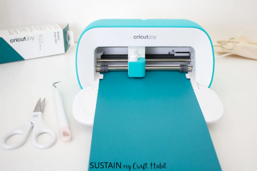 Loading the Cricut Joy machine with blue vinyl.