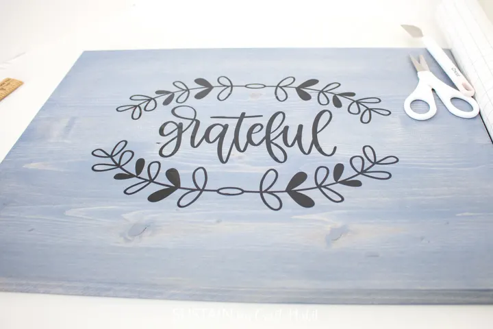 The word "grateful" on vinyl is transferred to the wood tray.