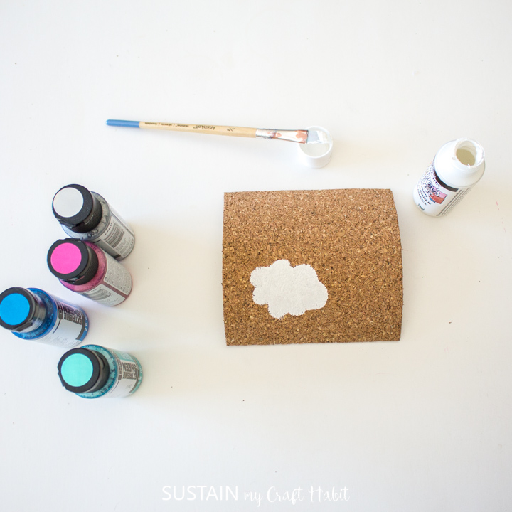 Painting a puffy shape onto a cork sheet.