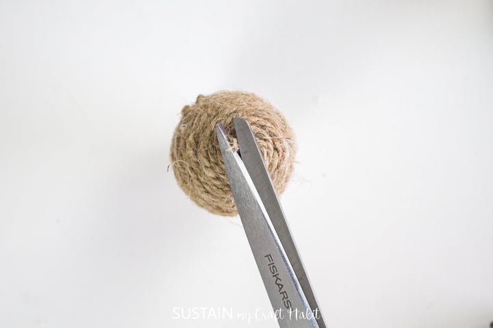 Cutting excess twine with scissors.