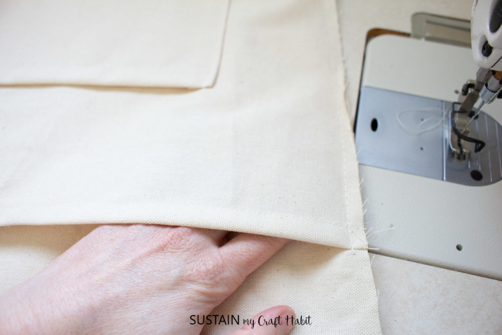 A hand holding the sewn canvas.