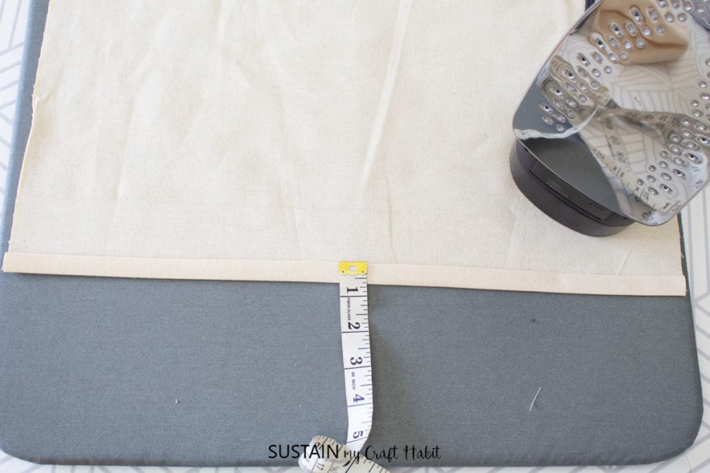 Folding the hem on the canvas and pressing it with an iron.