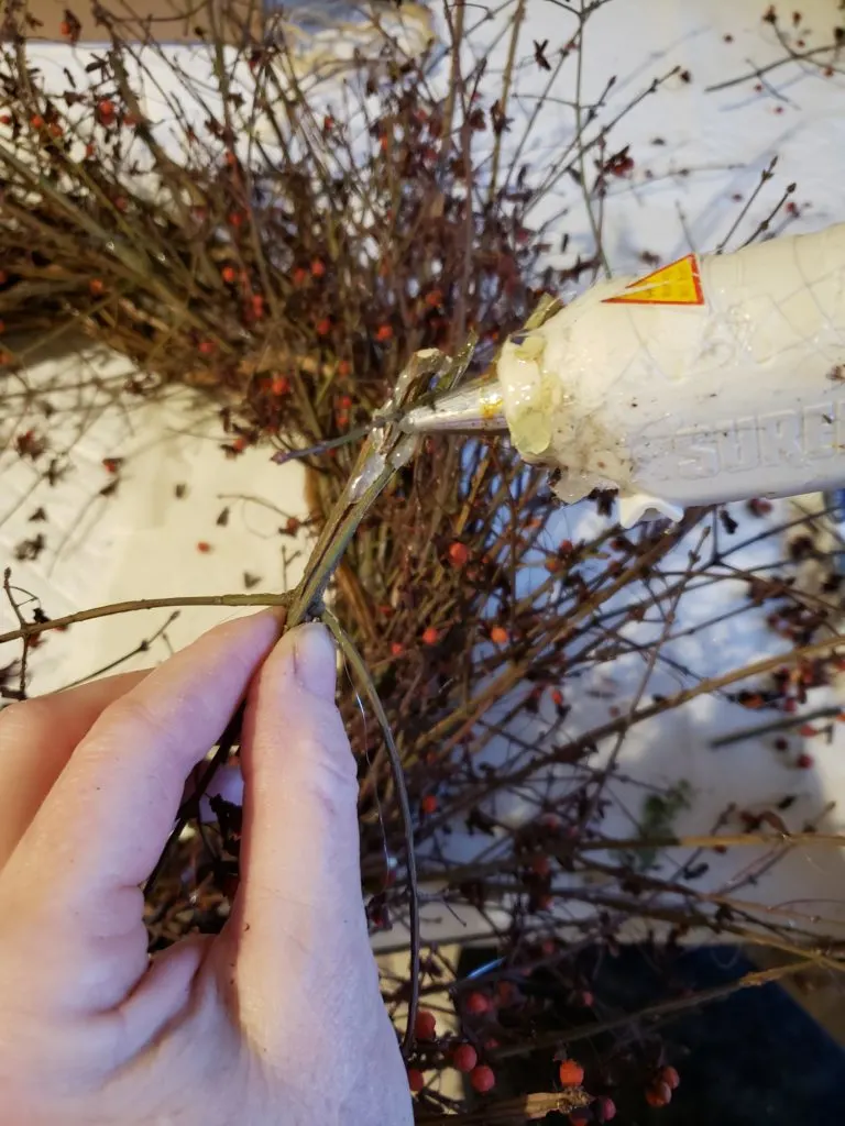 glueing the loose branches on to the wreath