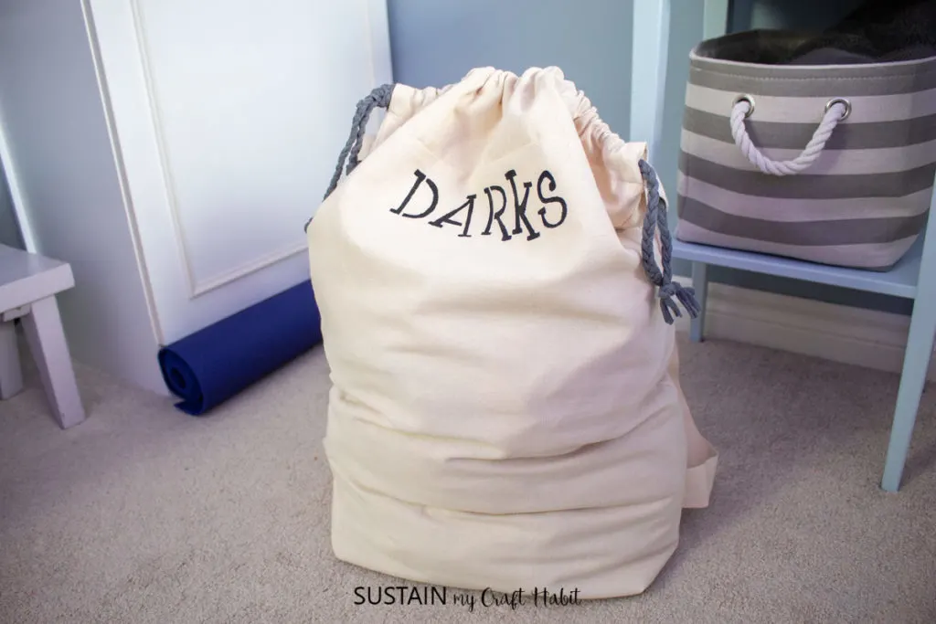 Laundry bag with the word "darks" filled with laundry.