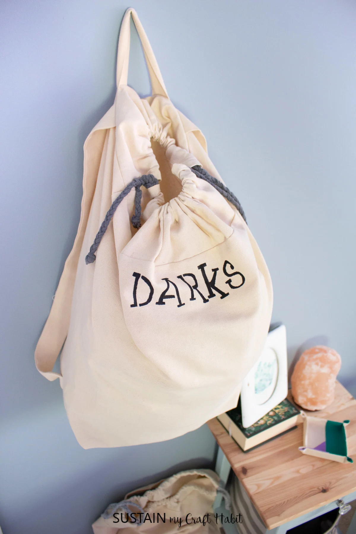Laundry bag with the word "darks" hanging from the wall.
