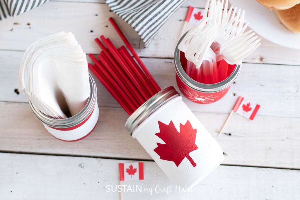 Canada Day painted mason jars filled with utensils.