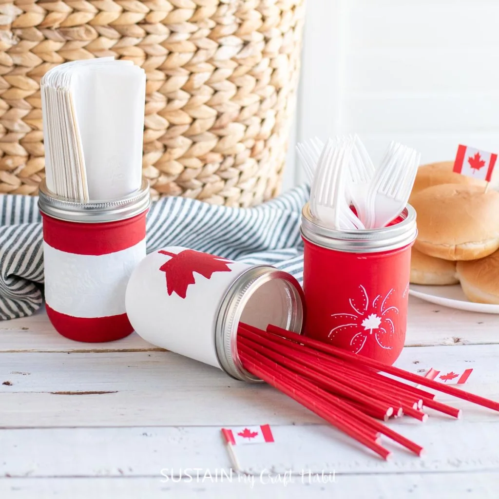 Canada Day painted mason jars filled with utensils.