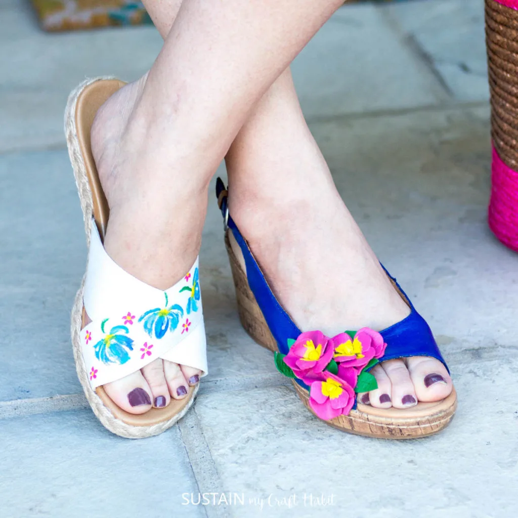 A woman wearing two different pretty painted sandals.
