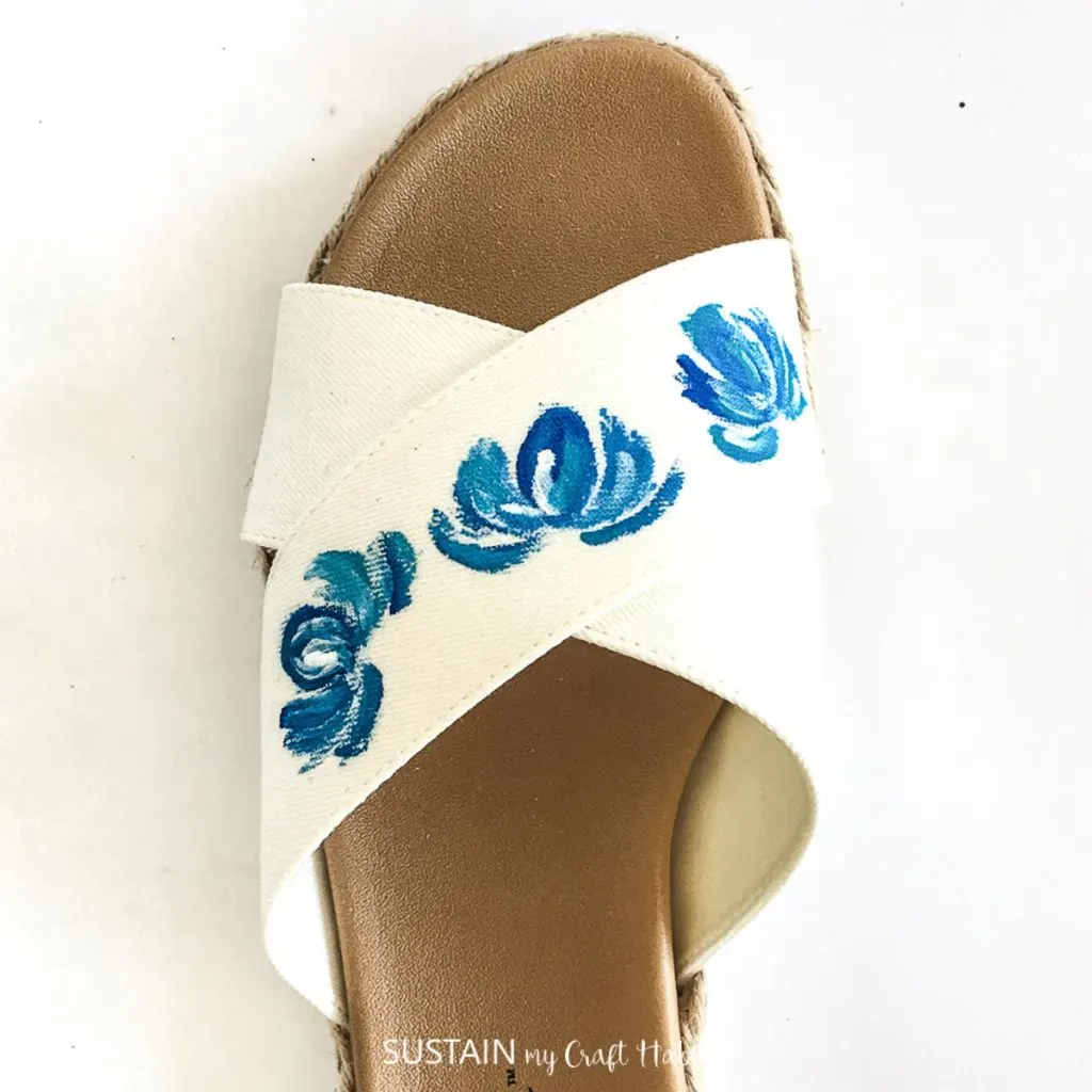 Creating more flowers on a white sandal.