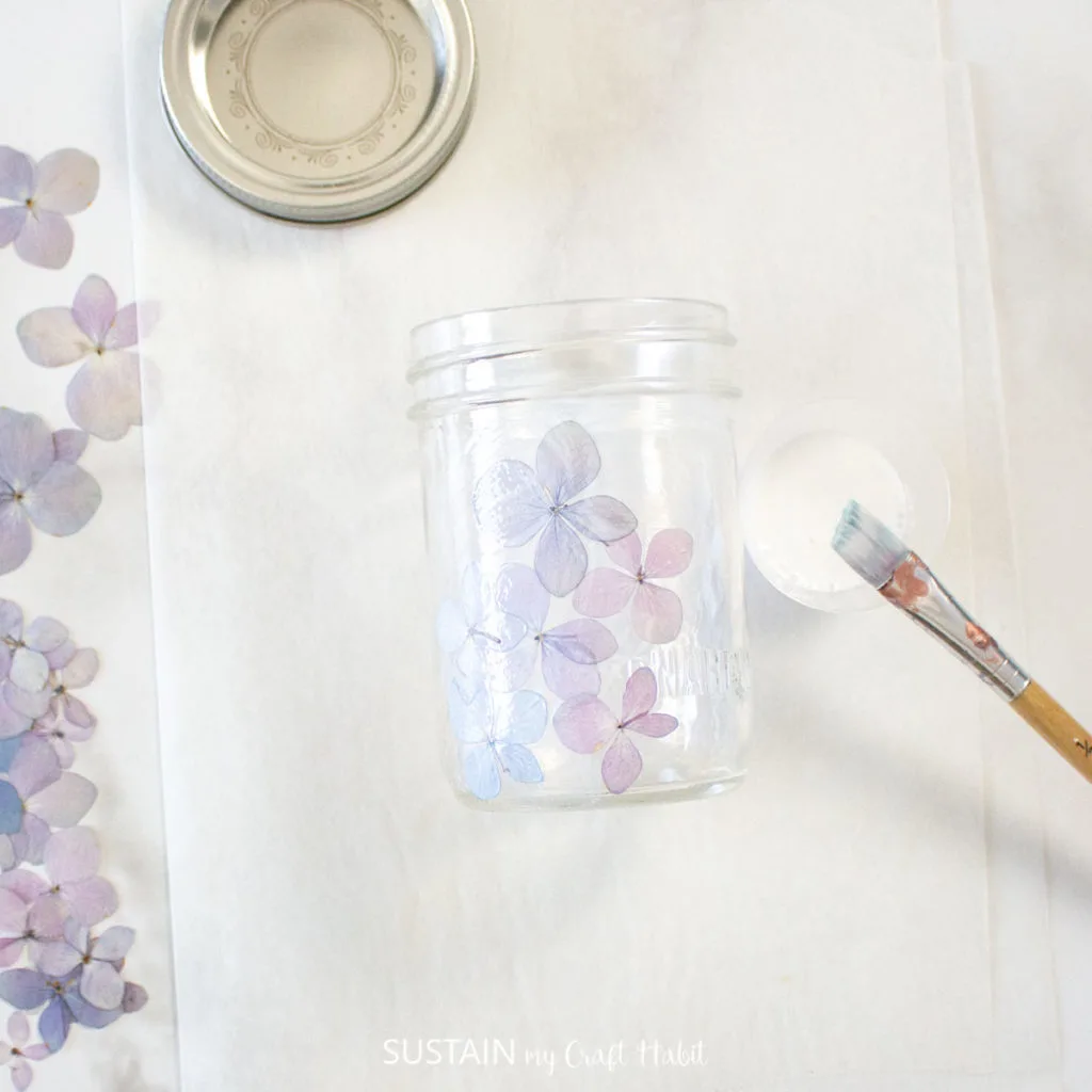 Covering the mason jar with hydrangea flowers.