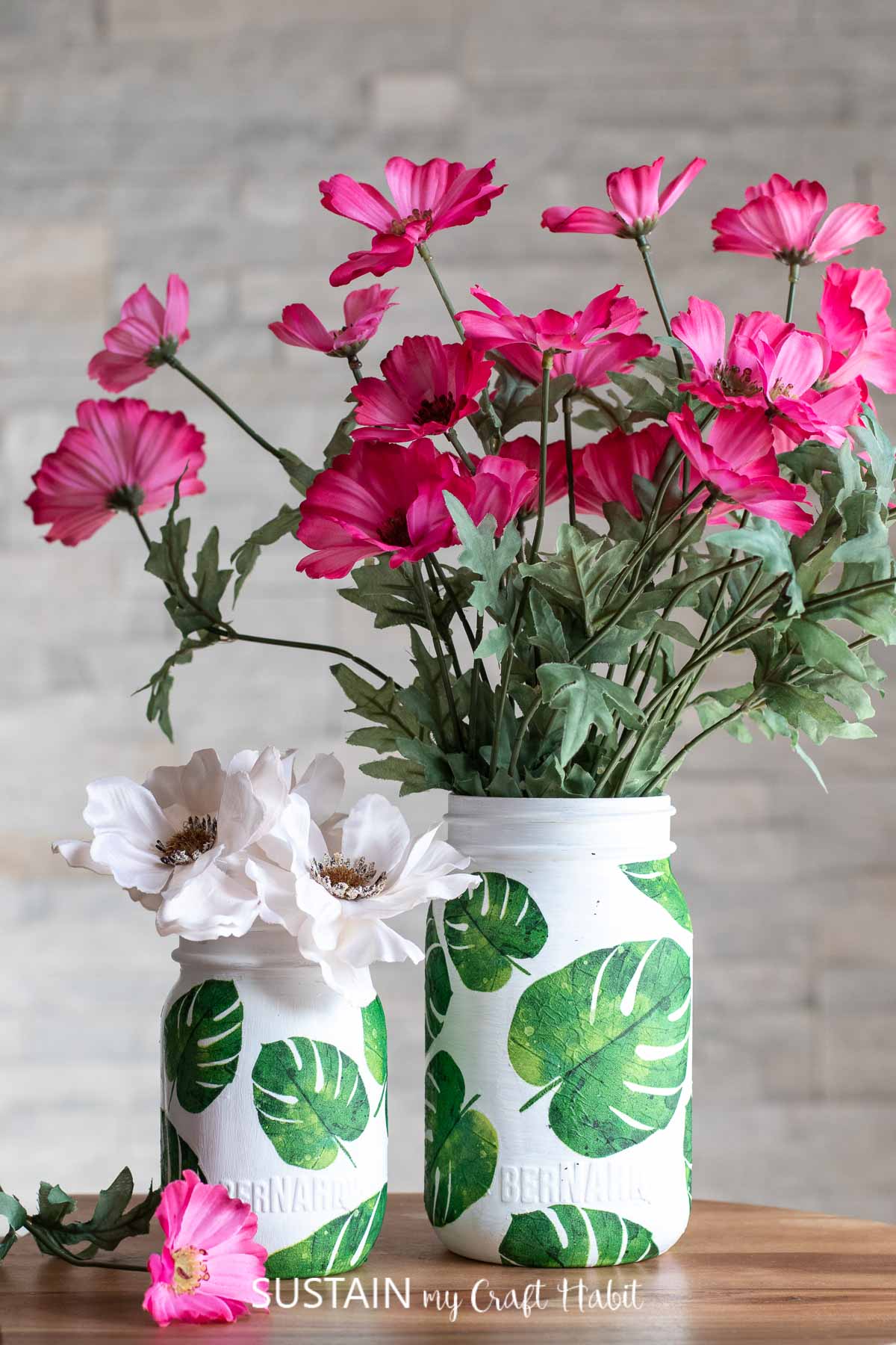 Napkin decoupage on glass jars filled with flowers.