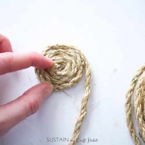Adding hot glue and wrapping the sisal rope around itself.