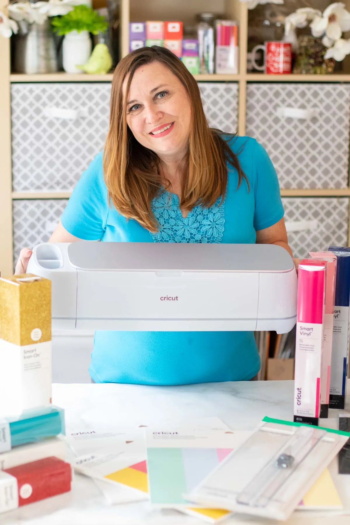 woman holding cricut maker 3 in craft room