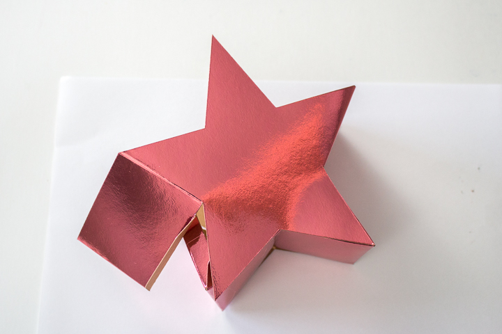 Gluing to complete the 3D paper star candy box.
