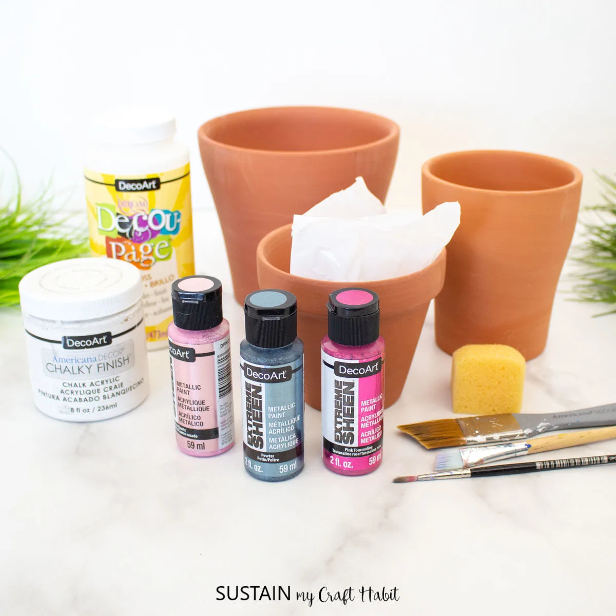 Materials needed to make painted marble effect terracotta pots including clay pots, paint, and paintbrushes.