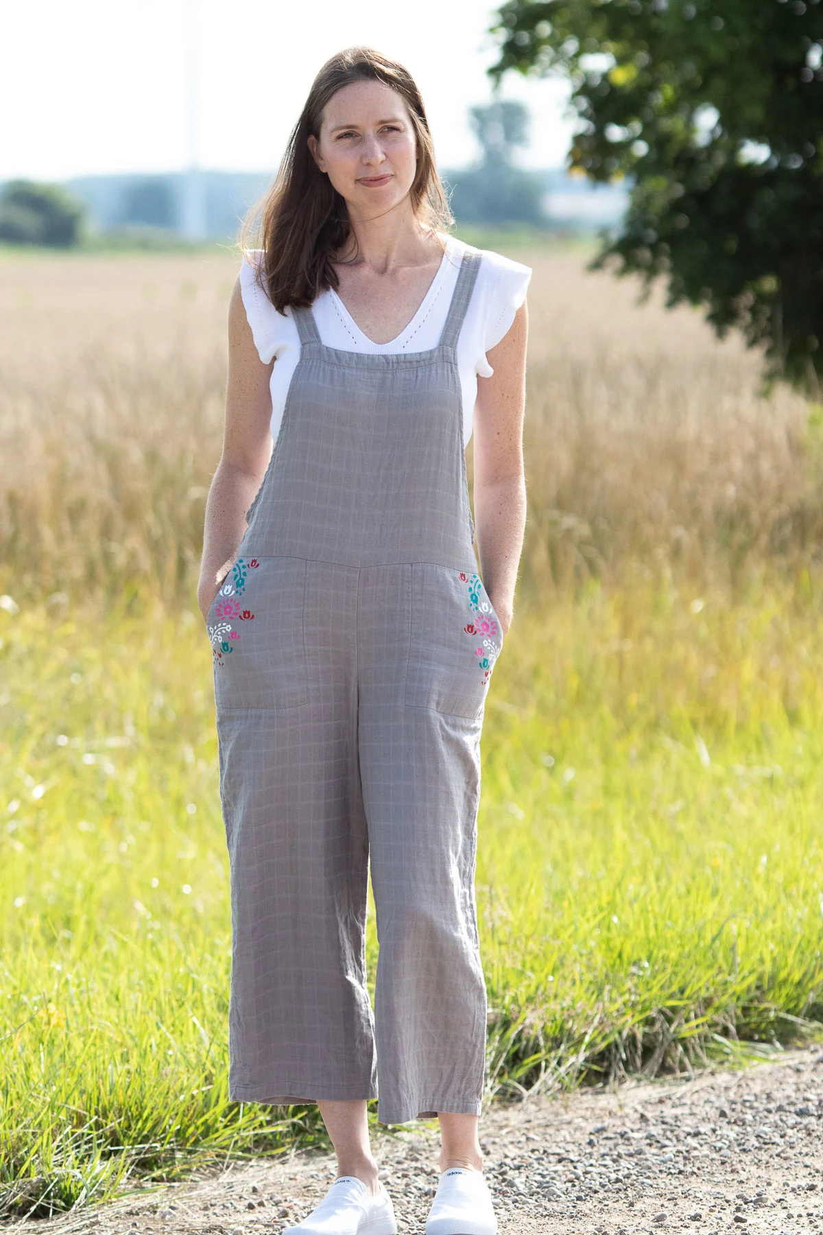 woman wearing jumpsuit standing near farm field