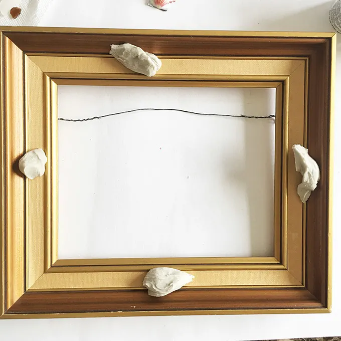 Separating the clay and placing it around the picture frame.
