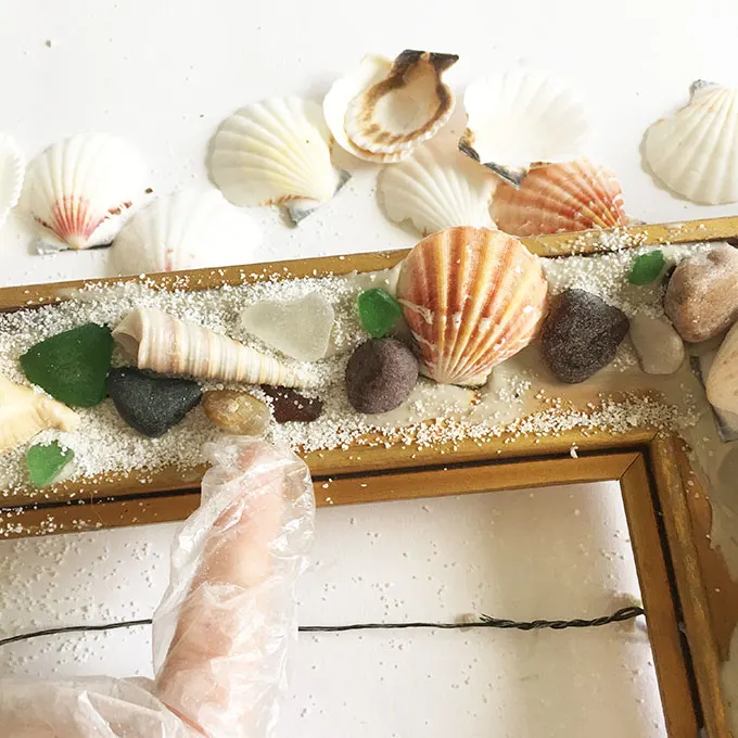 Adding white decorative sand to the picture frame.