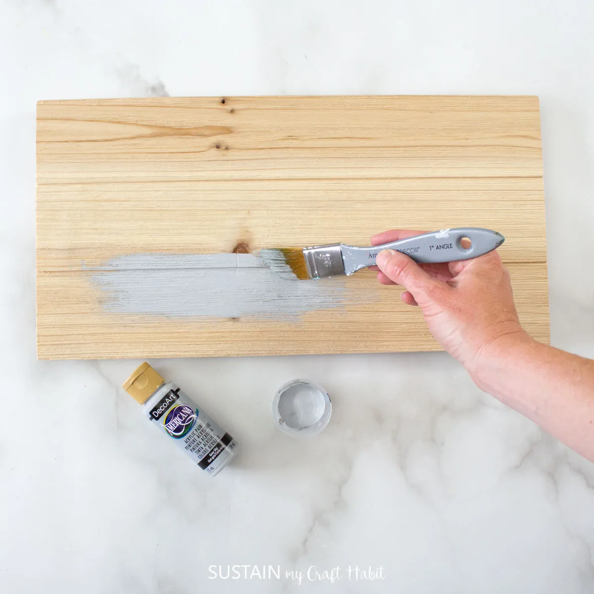 Painting the wooden pallet grey.