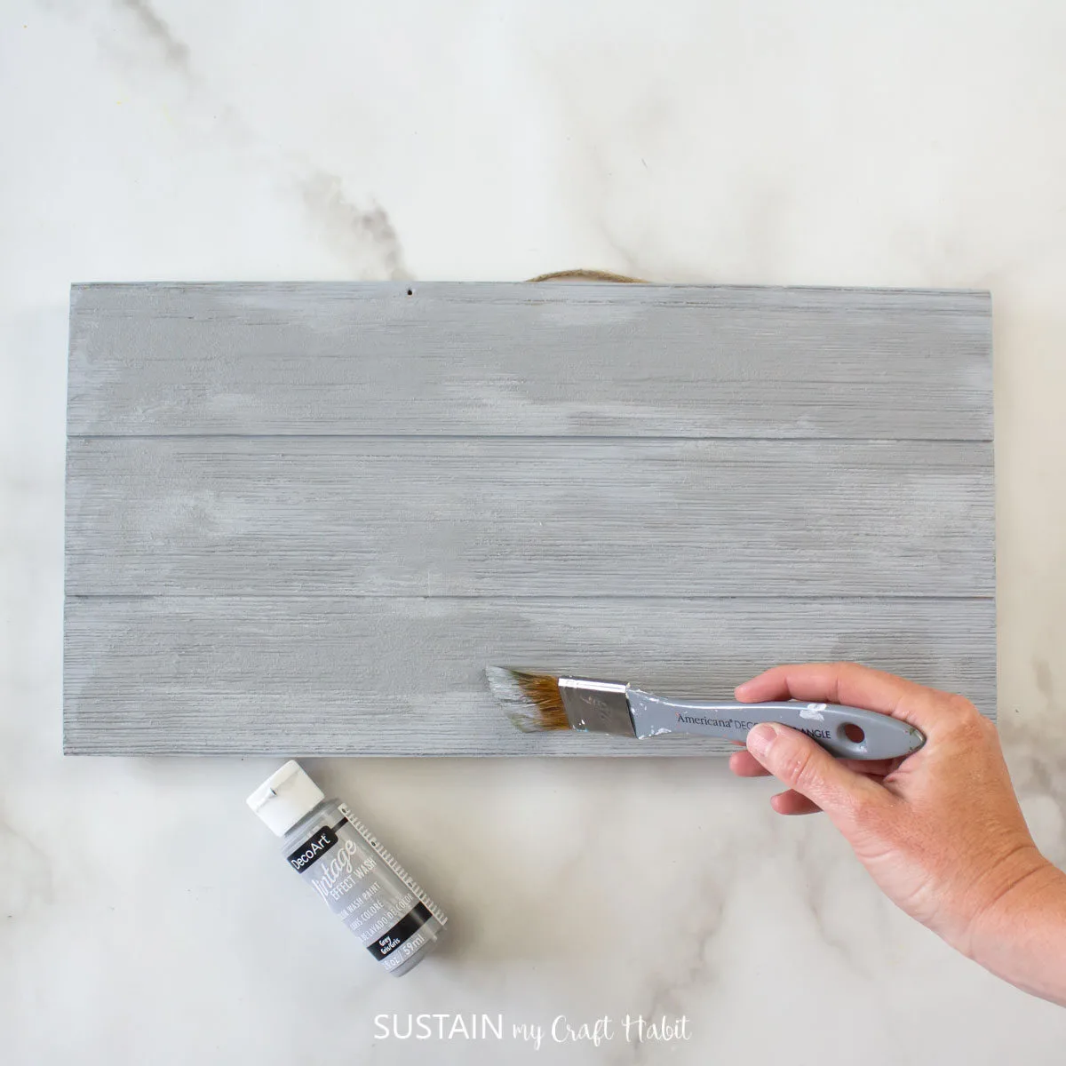 Adding vintage grey paint over the painted pallet wood.