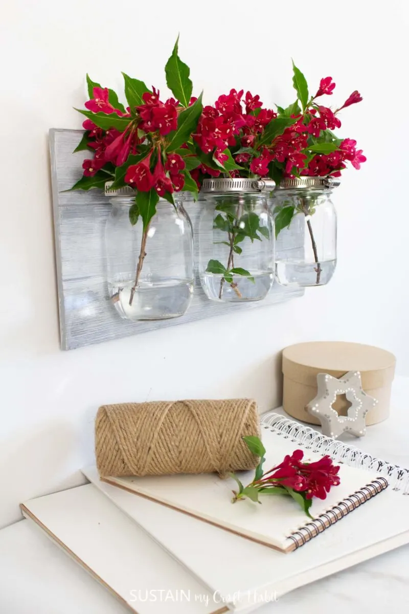 Mason jar wall sconce filled with flowers.