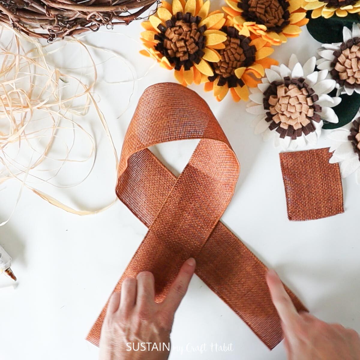 Folding the brown burlap ribbon to make a bow.