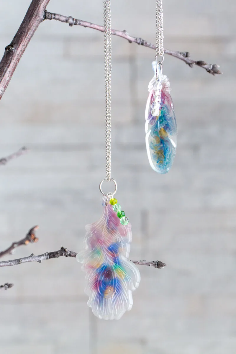 Resin feather pendants hanging from a branch.