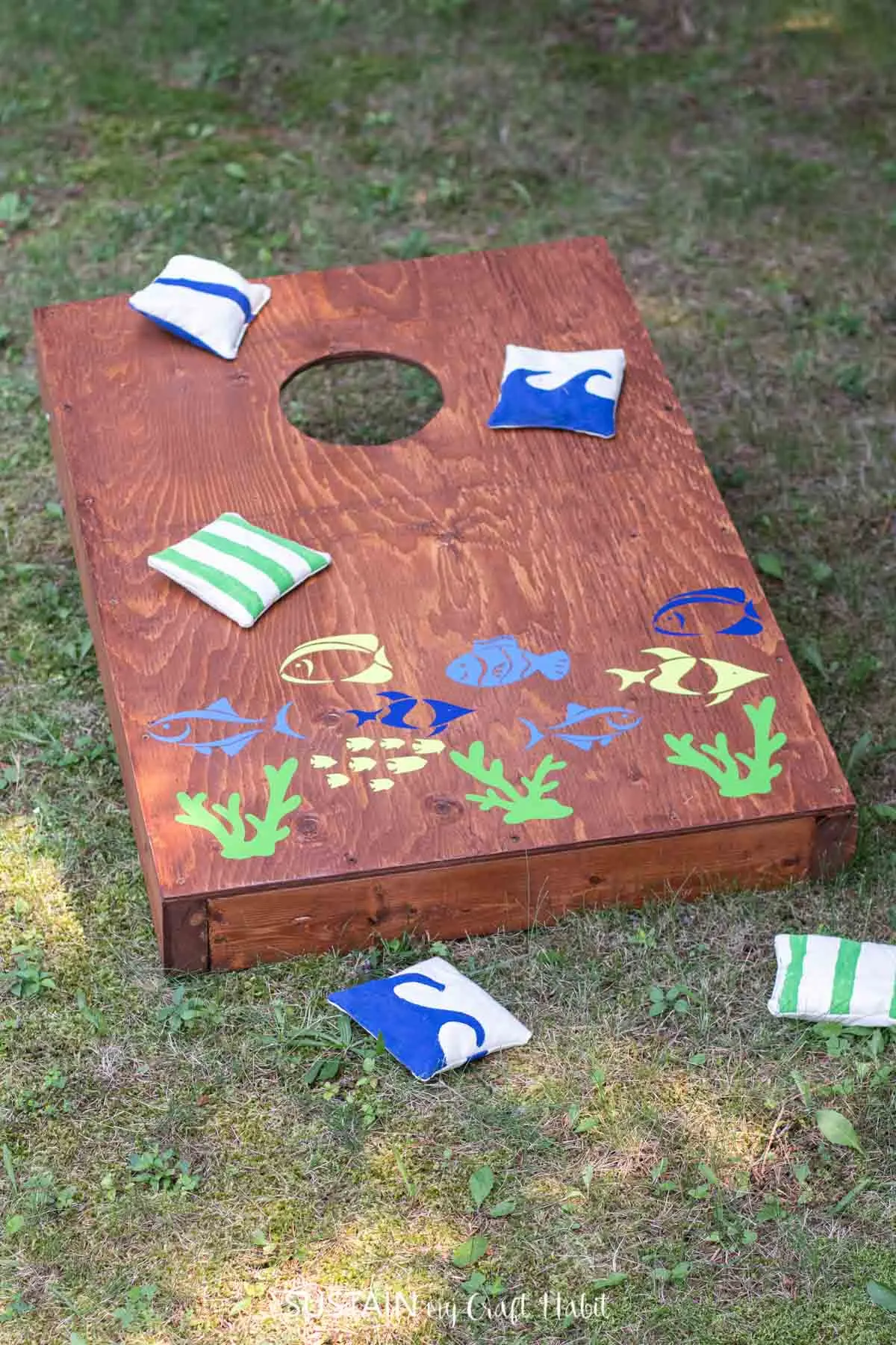 Cornhole board game embellished with fish decals using Cricut Joy and Smart Vinyl.